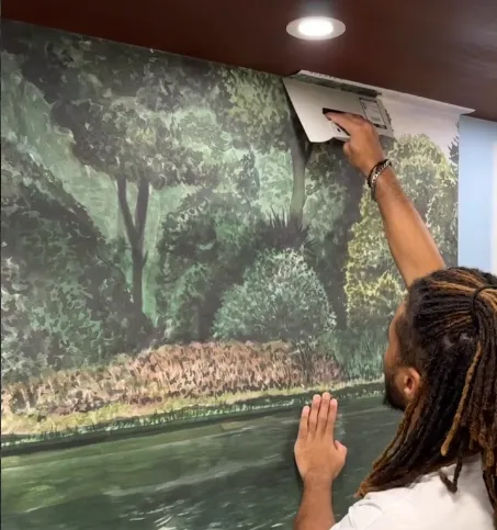 Pose d'un papier peint mural représentant une forêt, par un artisan Bleau'décor